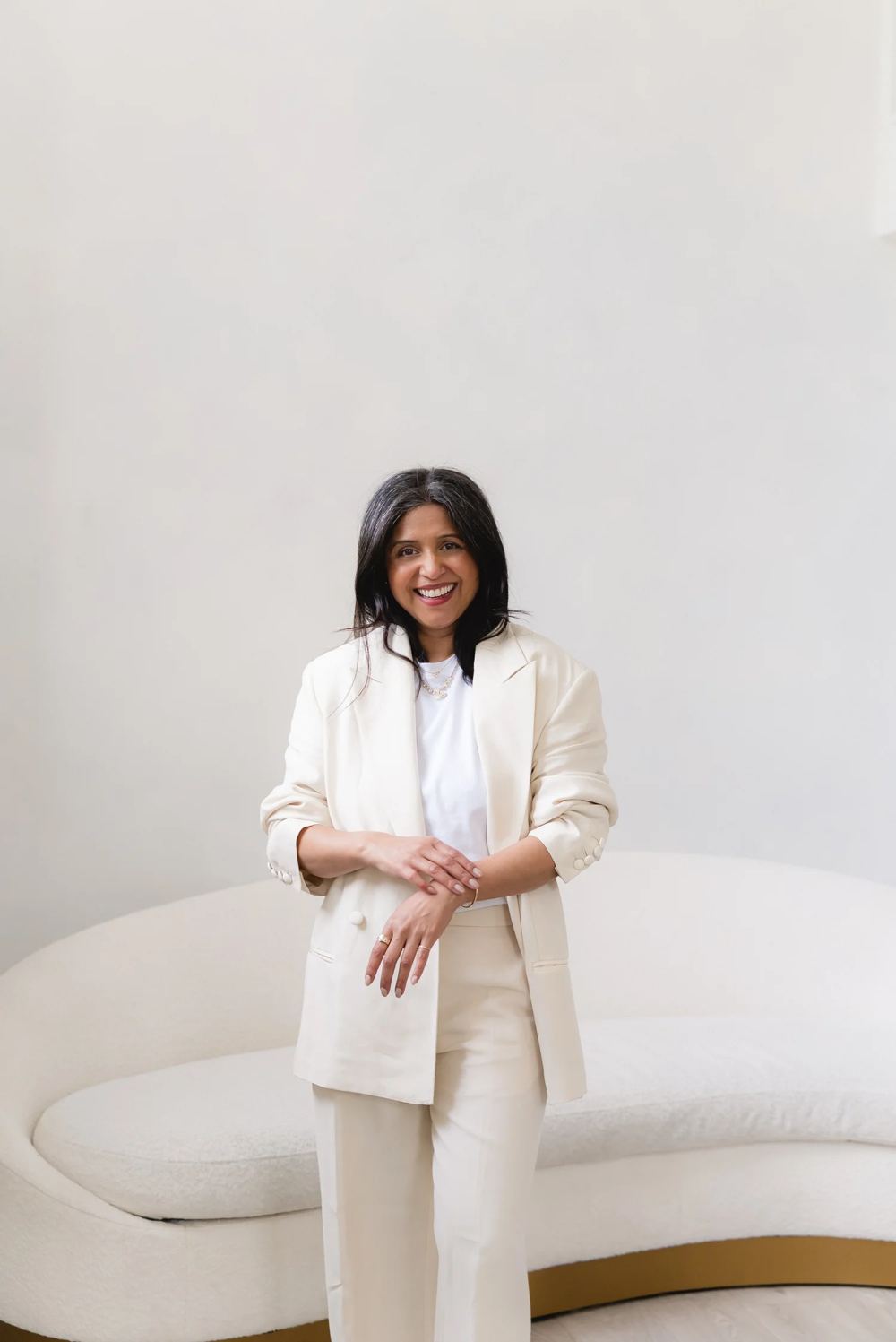 Dr Nikita Mehta in a cream suit, smiling