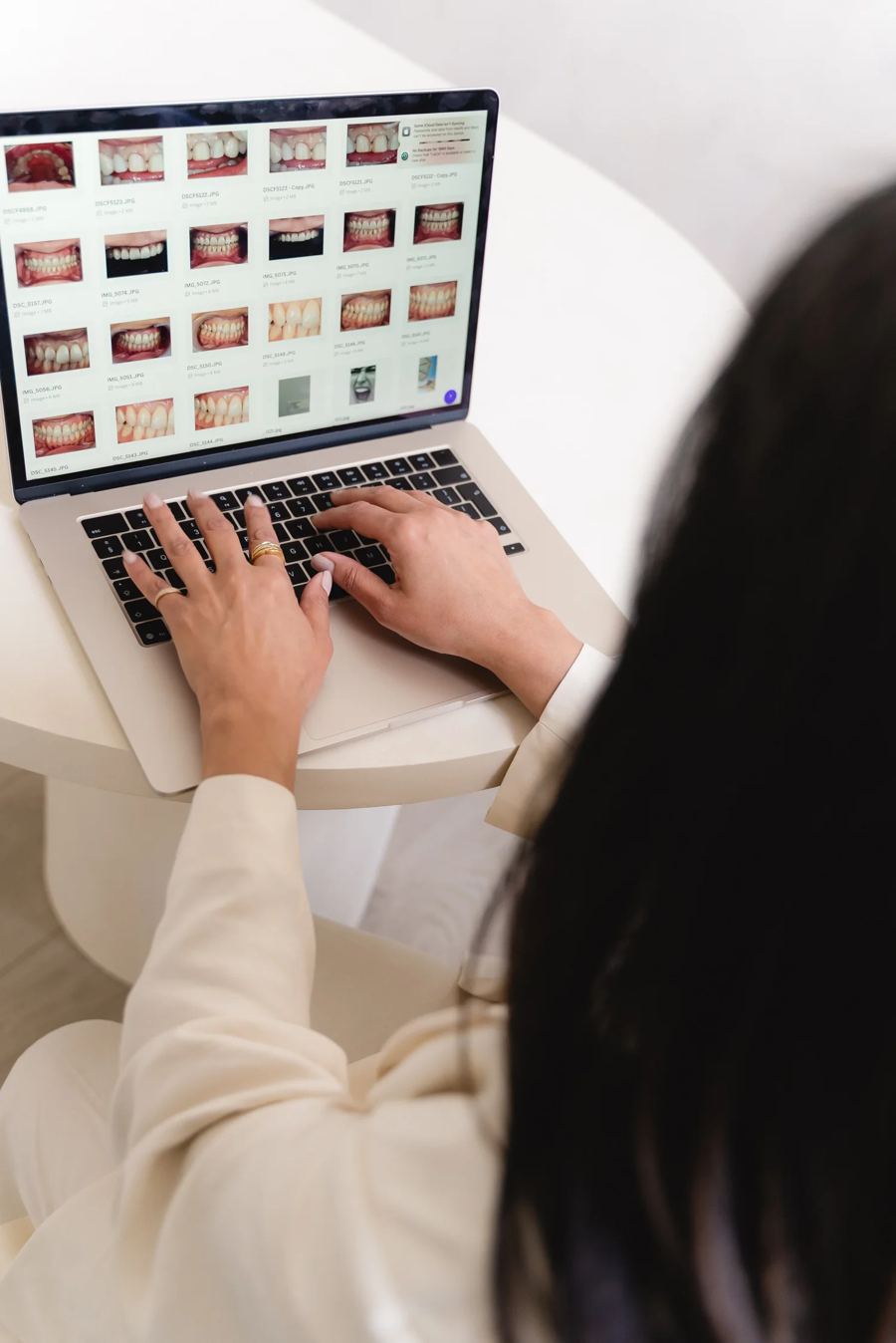 Dr Nikita Mehta reviewing smile photographs on a laptop